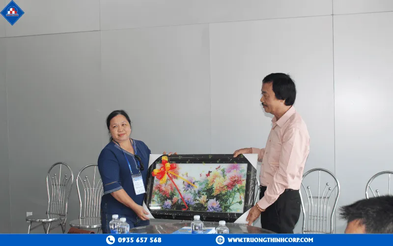Master Tran Thoai Chau presents a souvenir to the factory