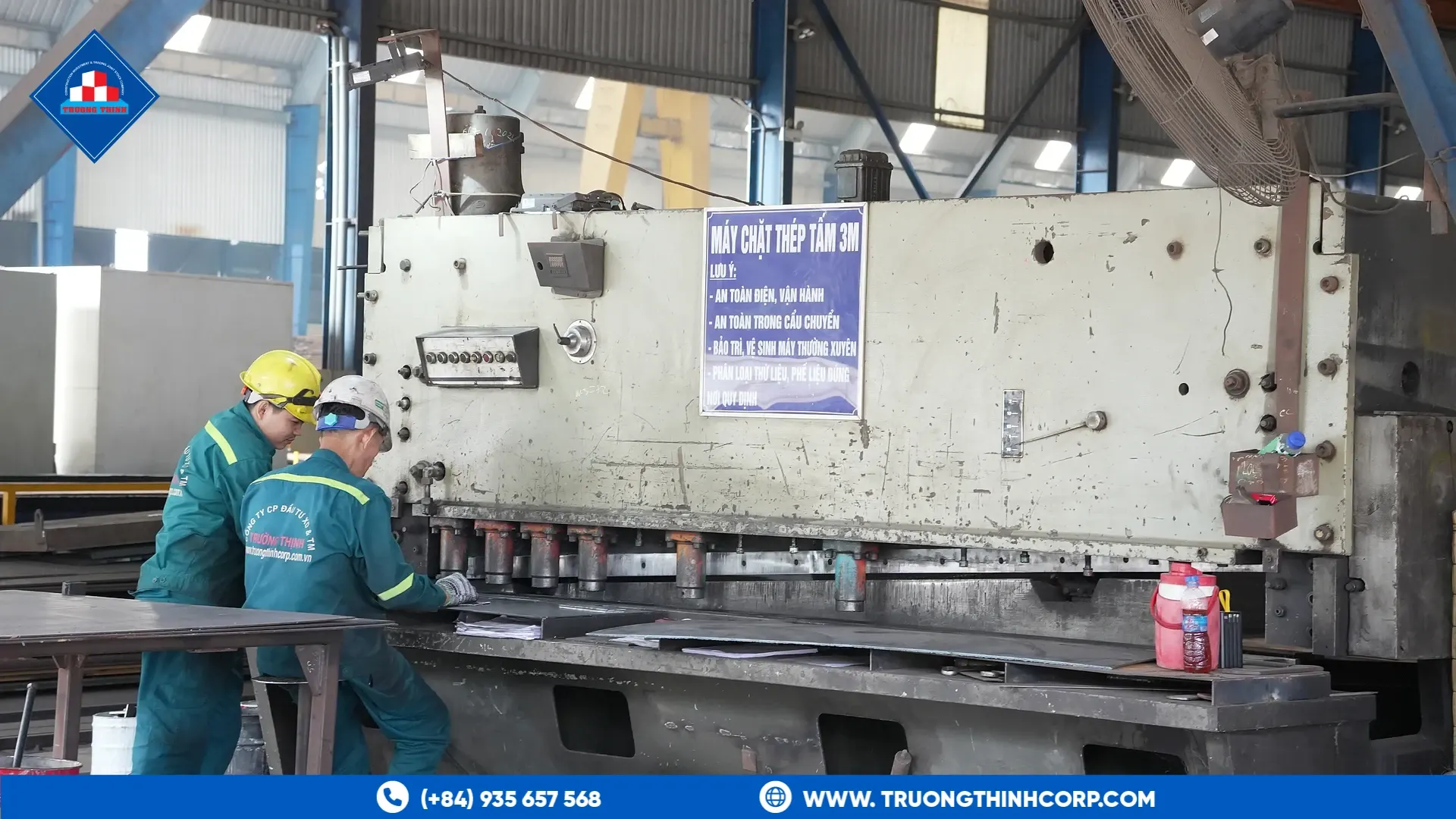 Workers operating a steel plate shearing machine at Truong Thinh Corp