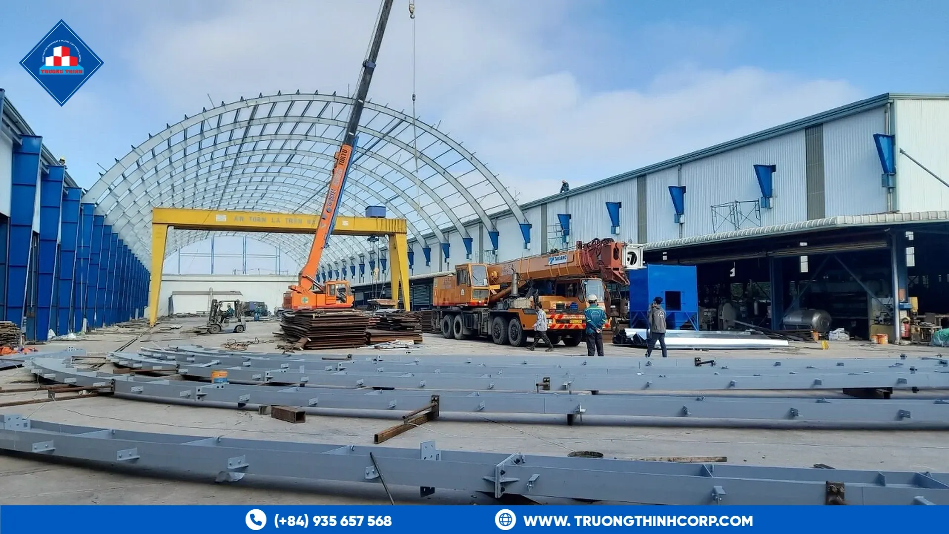 Arched steel frame being assembled with a mobile crane at Truong Thinh Corp's factory