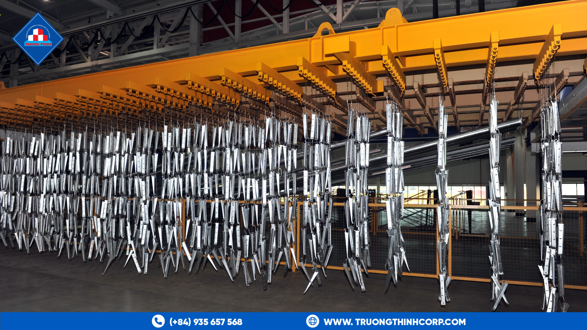 Hot-dip galvanized steel components hanging on a rack in a galvanizing plant