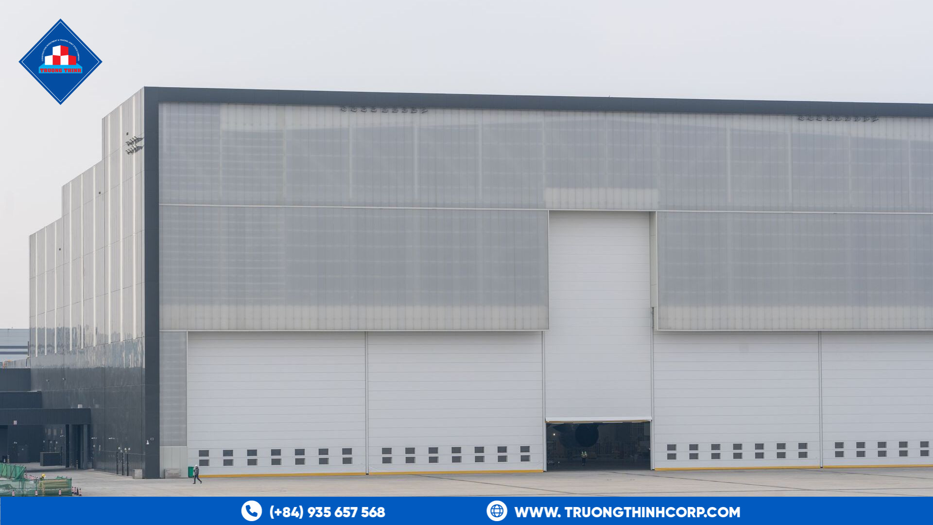 Exterior of a modern commercial warehouse building with a steel-framed metal facade