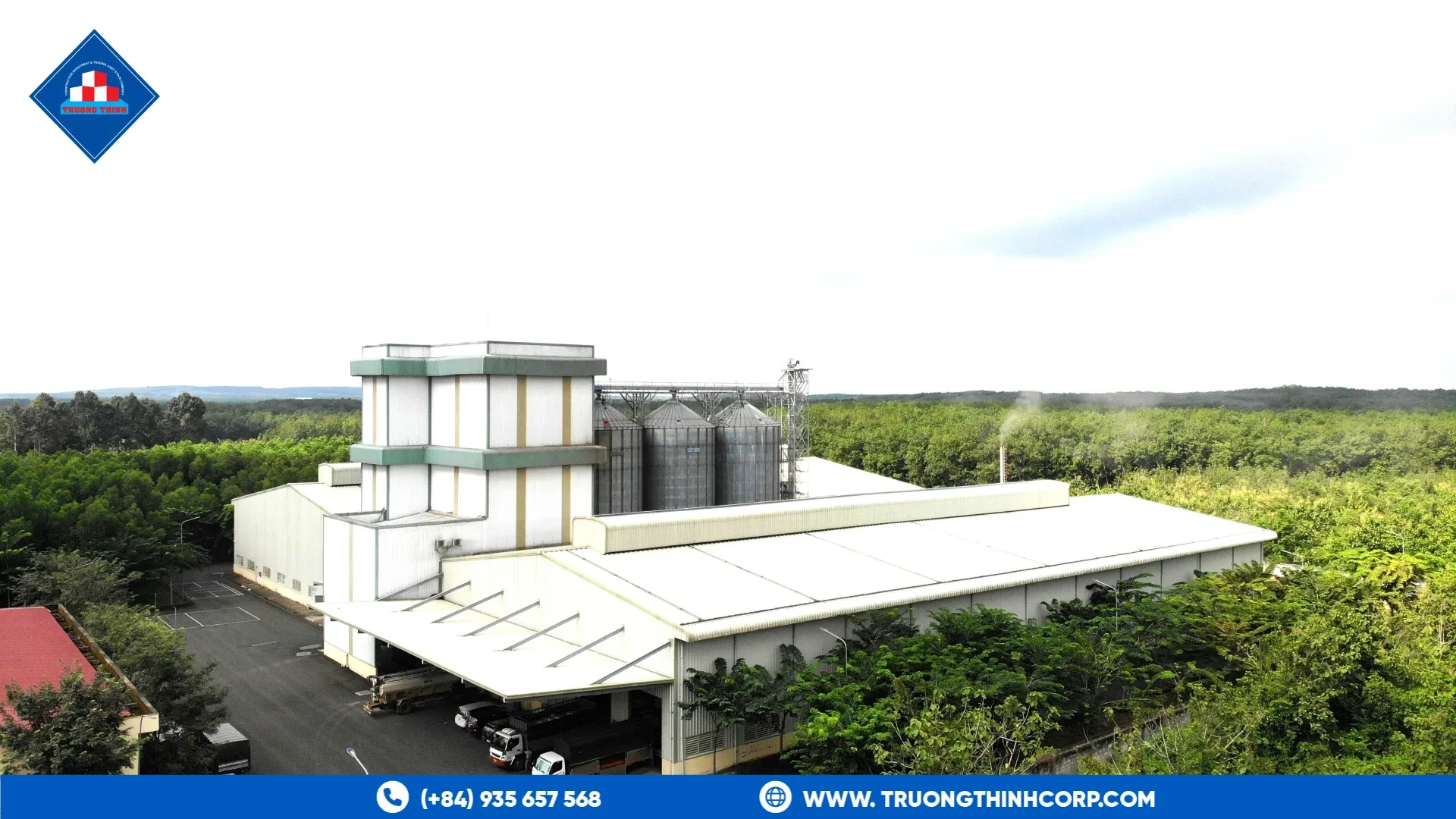 Feed processing building with silos and a covered loading area at an existing steel-framed project
