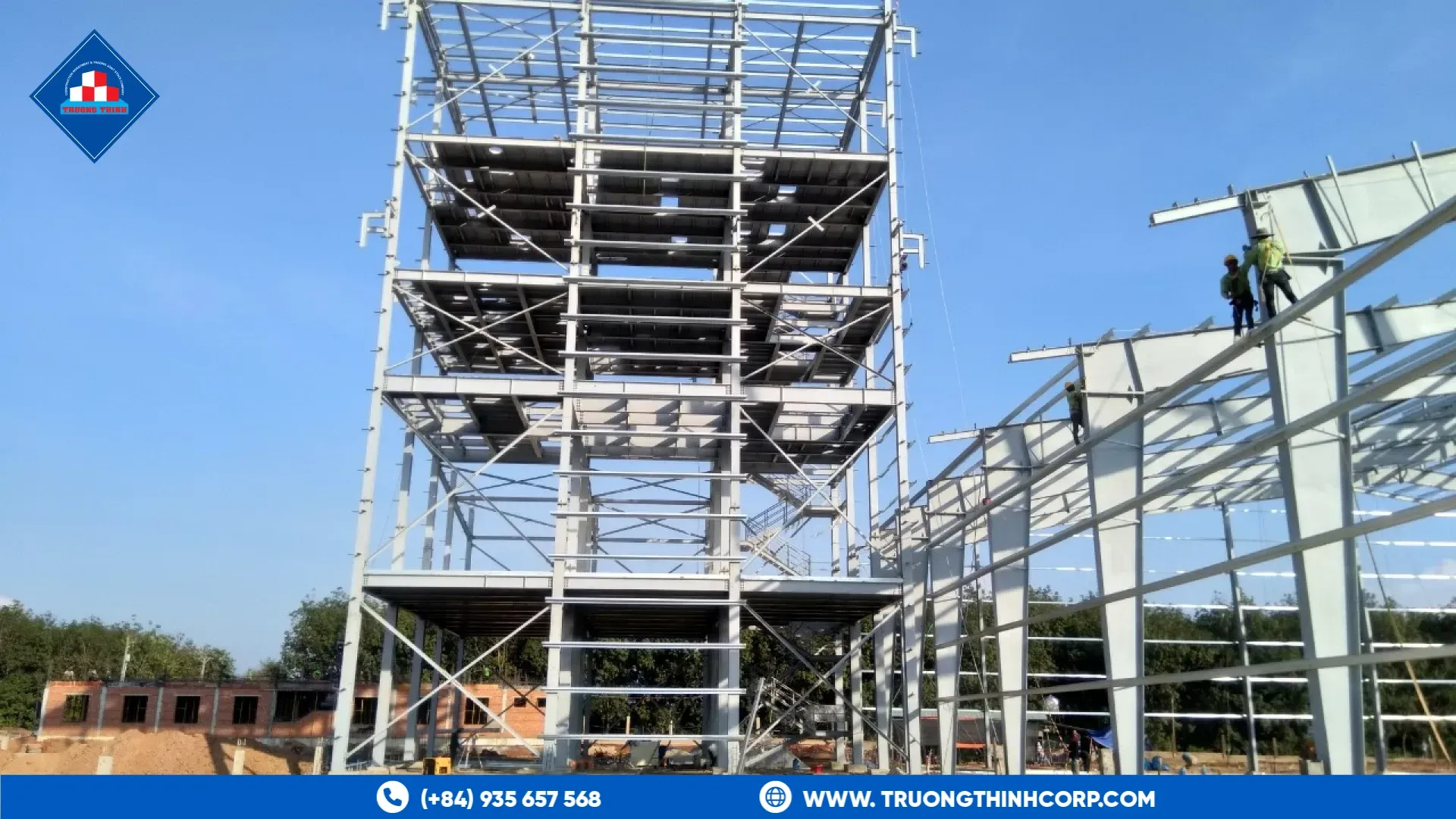 Bolted steel lattice tower frame rising against a clear sky at the DABACO feed mill project