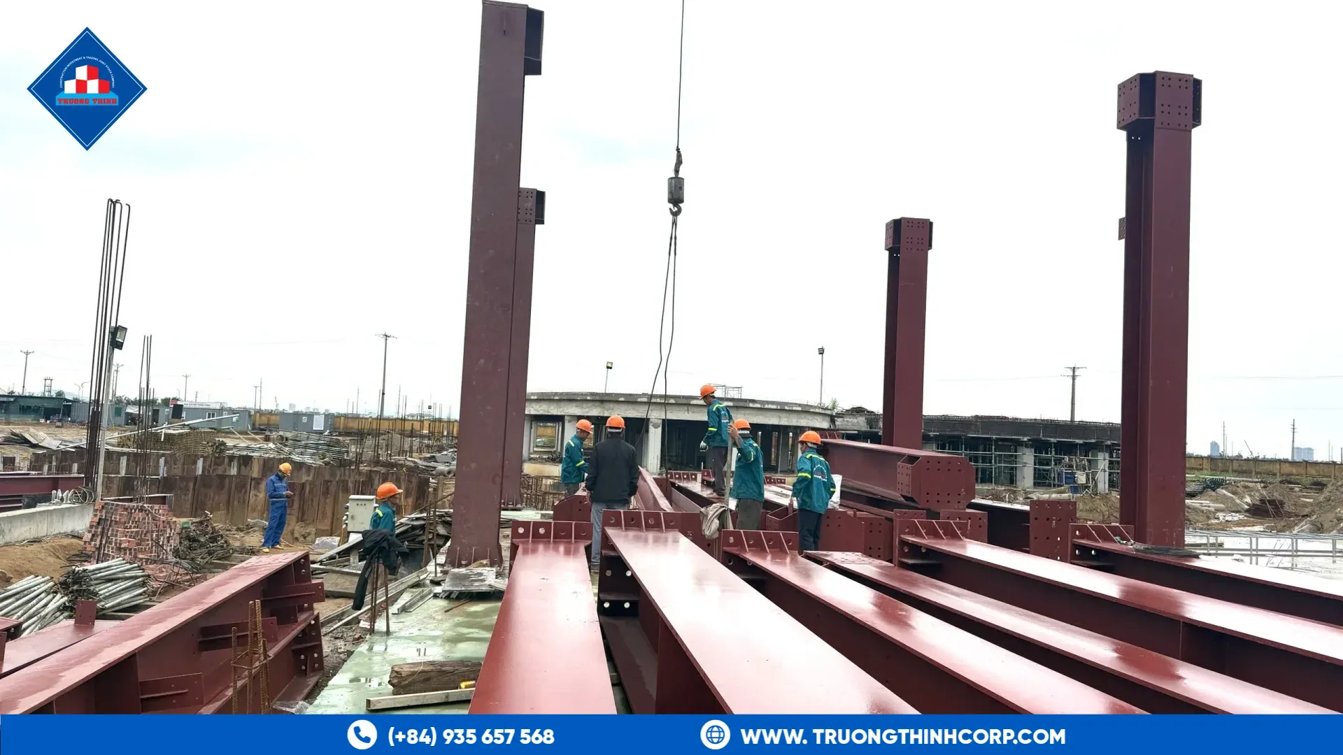 Heavy fabricated steel beams laid out for erection with columns rising behind, Nutreco Ha Tinh feed mill project