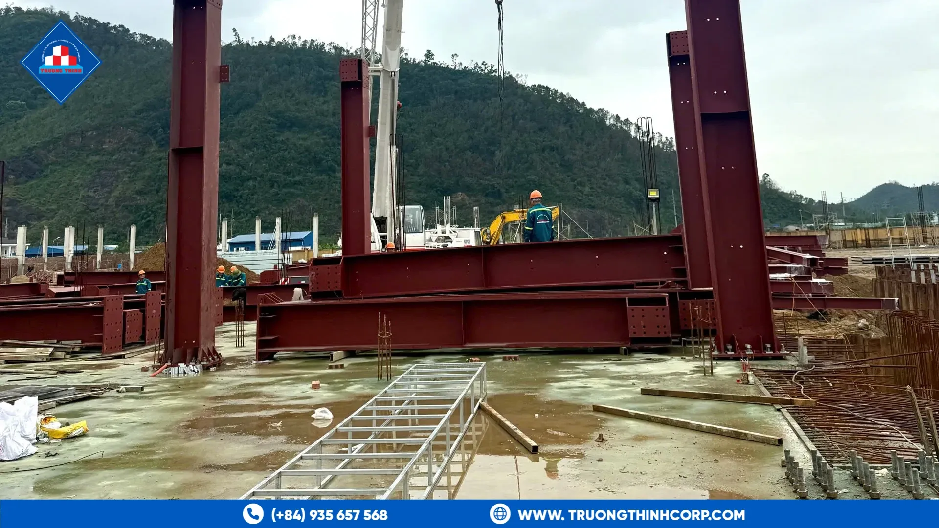 Tall steel columns being lifted by mobile crane during erection, a wind-governed tall structure example from Nutreco Ha Tinh